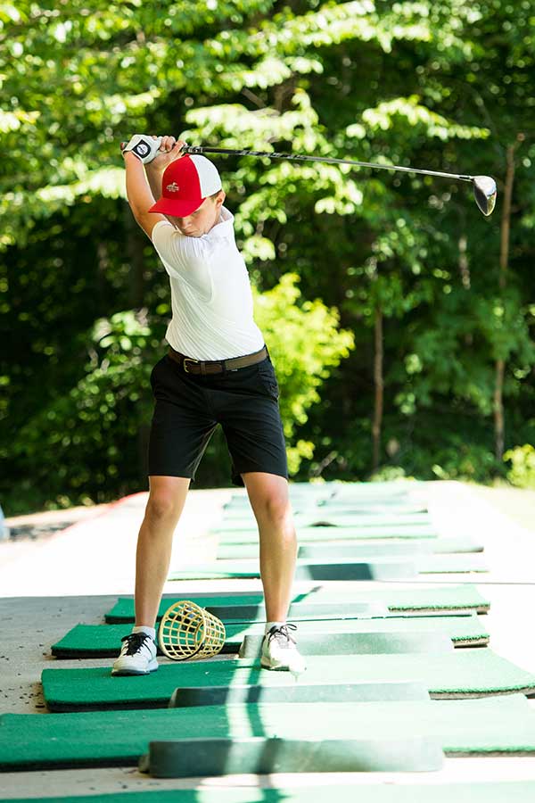 Boy practicing golf swing